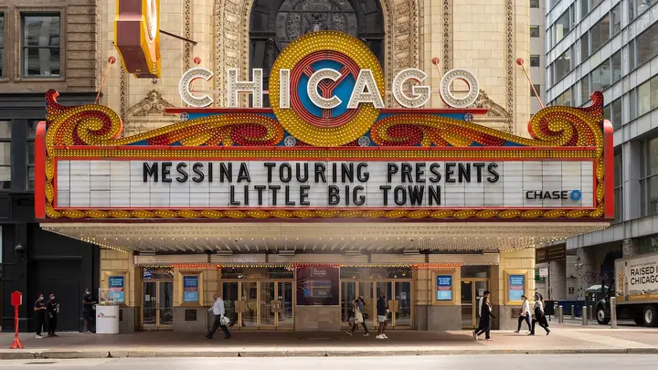 The Chicago Theatre's famous vertical CHICAGO sign and lit marquee on State Street.