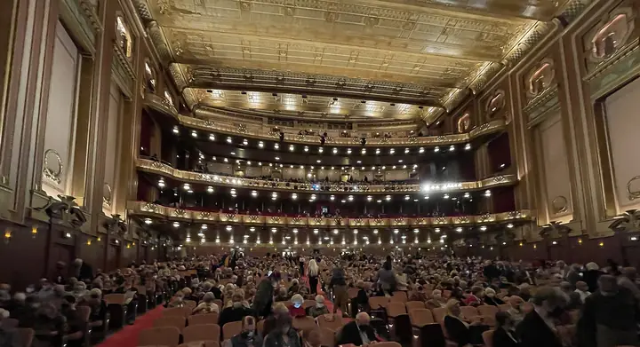 The ornate gold auditorium of the Civic Opera House, home of the Lyric Opera of Chicago, filled with an audience.